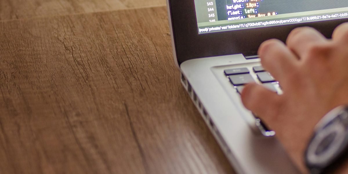 Closeup of a developer's hands typing on a laptop
