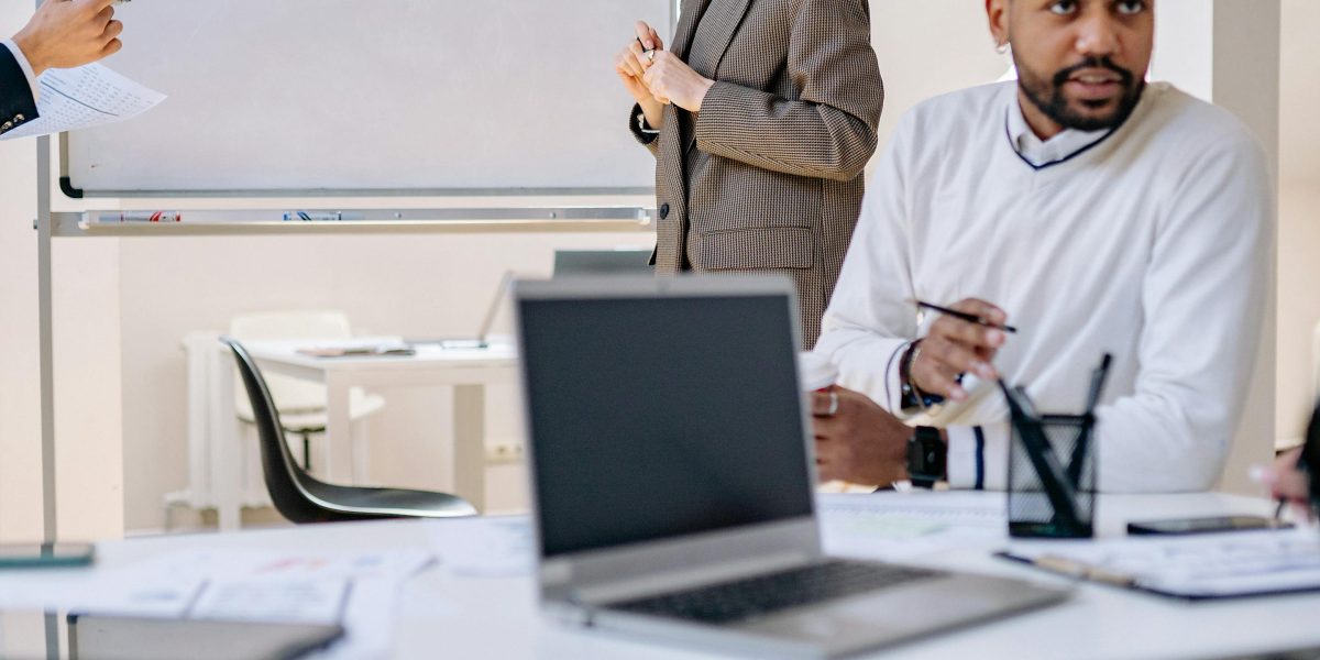 A diverse team collaborates around a whiteboard, discussing strategic plans and drawing connections, symbolizing complex cloud architecture discussions.