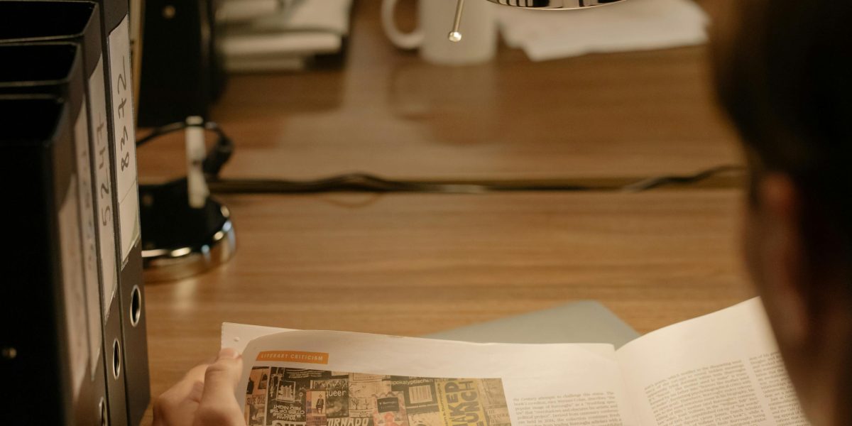A person thoughtfully reviews documents, symbolizing the need to analyze tech job market signals and plan their career path.