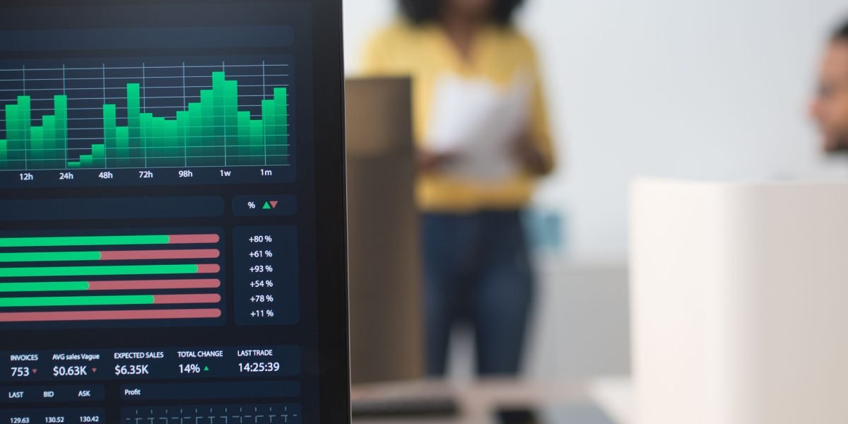 A team of professionals collaborating, focused on analyzing multiple monitoring dashboards to track real-time system performance.