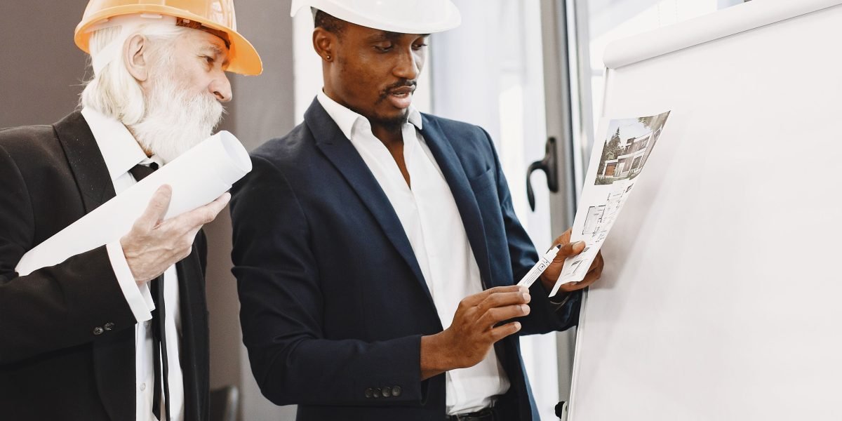 A group of architects or engineers collaborating and sketching complex system designs on a whiteboard, focusing on resilience and scalability.