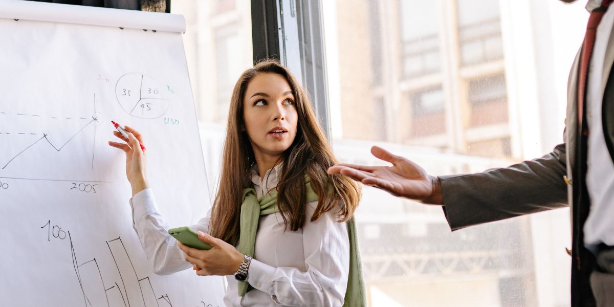 A group of colleagues collaborating and explaining complex data insights using visual aids, emphasizing effective communication.
