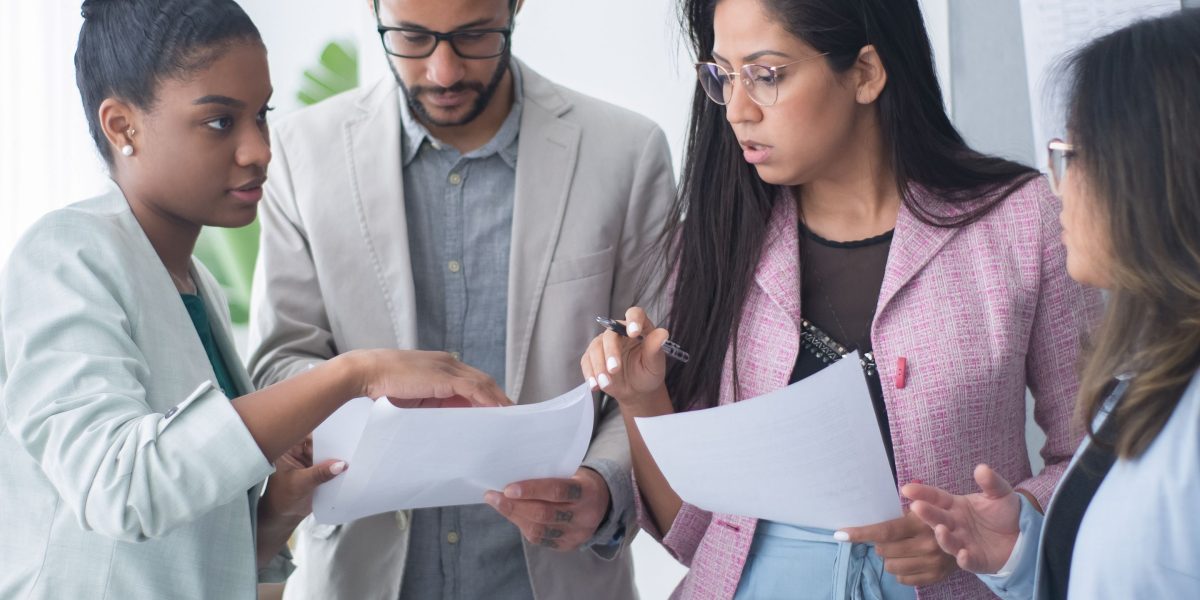 A diverse team works together, reflecting collaboration and empowerment in building solutions without traditional code.