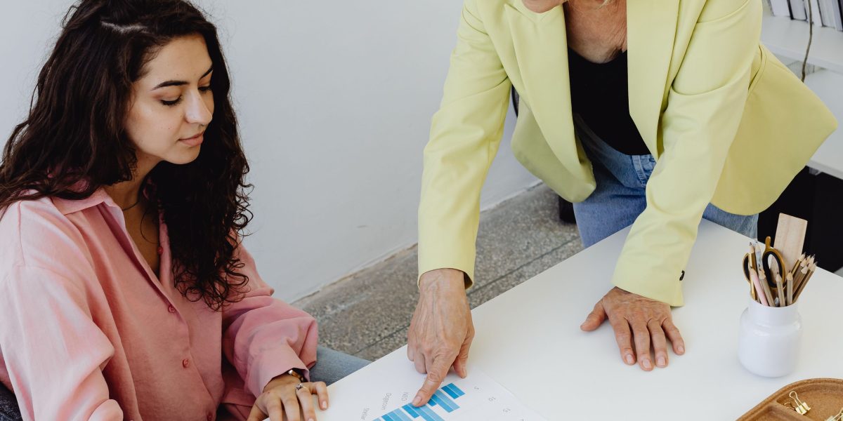 A senior engineer provides guidance and support to a junior team member during a one-on-one mentorship session.