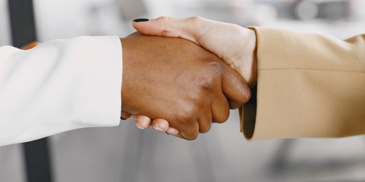 Professionals engaging in a positive interaction, symbolizing career advancement after earning an online degree.