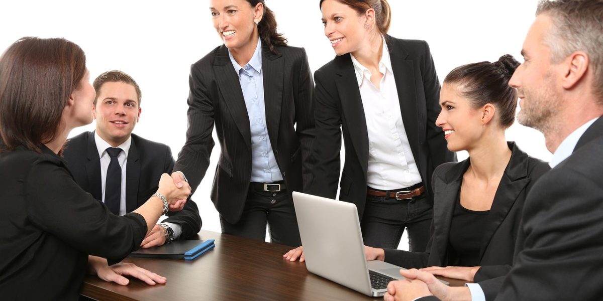 Two business professionals shake hands, symbolizing a new partnership and mutual understanding.