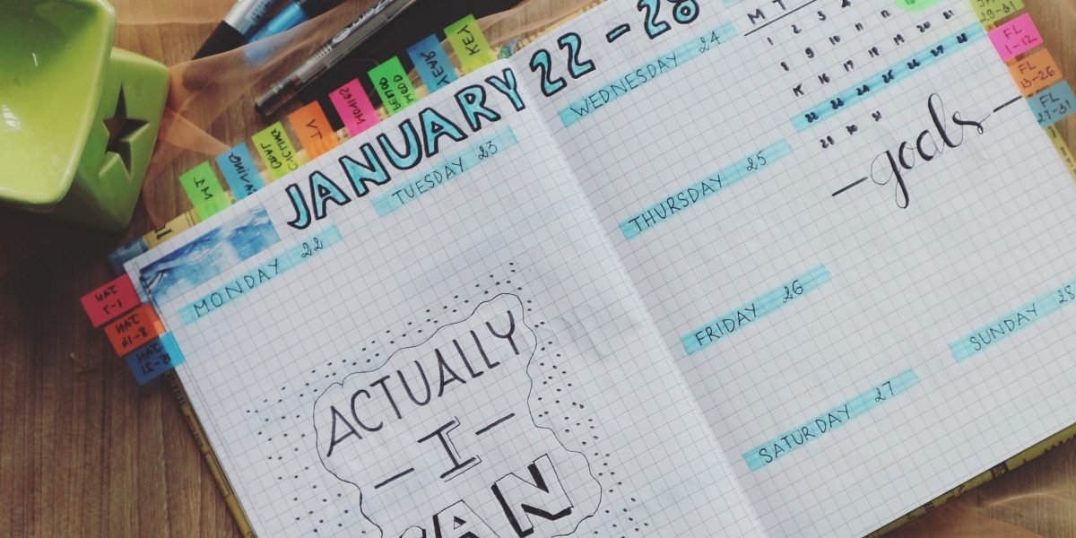 A person effectively organizing their planner with academic tasks and personal appointments, demonstrating successful time management.