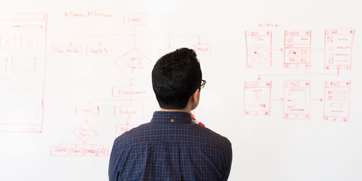 A person focused on a tablet, thoughtfully considering future trends and long-term strategic decisions in technology.